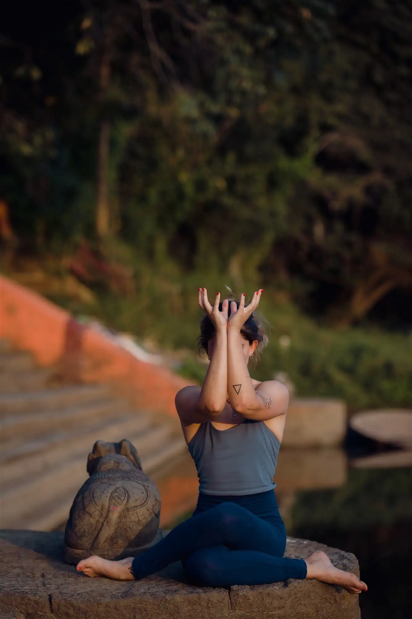Postura sentada con las manos en namaste sobre la cabeza